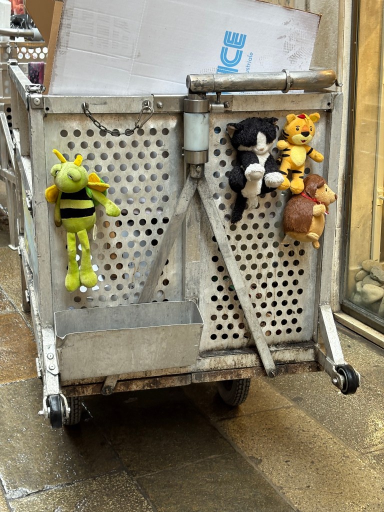 quattro peluche appesi in coda ad un carro di un operatore ecologico Veritas a Venezia